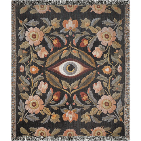 A luxury woven jacquard blanket in three sizes featuring an all-over wild herb botanical pattern of stylized blossoms and foliage in muted gold, olive, lavender, and pewter on a deep black cotton ground; finely twisted multicolor fringe edges complete the artful tapestry weave, ideal as a cozy sofa throw or dramatic wall hanging.
